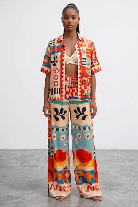 Model wearing Hush Boutique Art of Vacation two-piece set with abstract print in red, turquoise, orange, and cream.