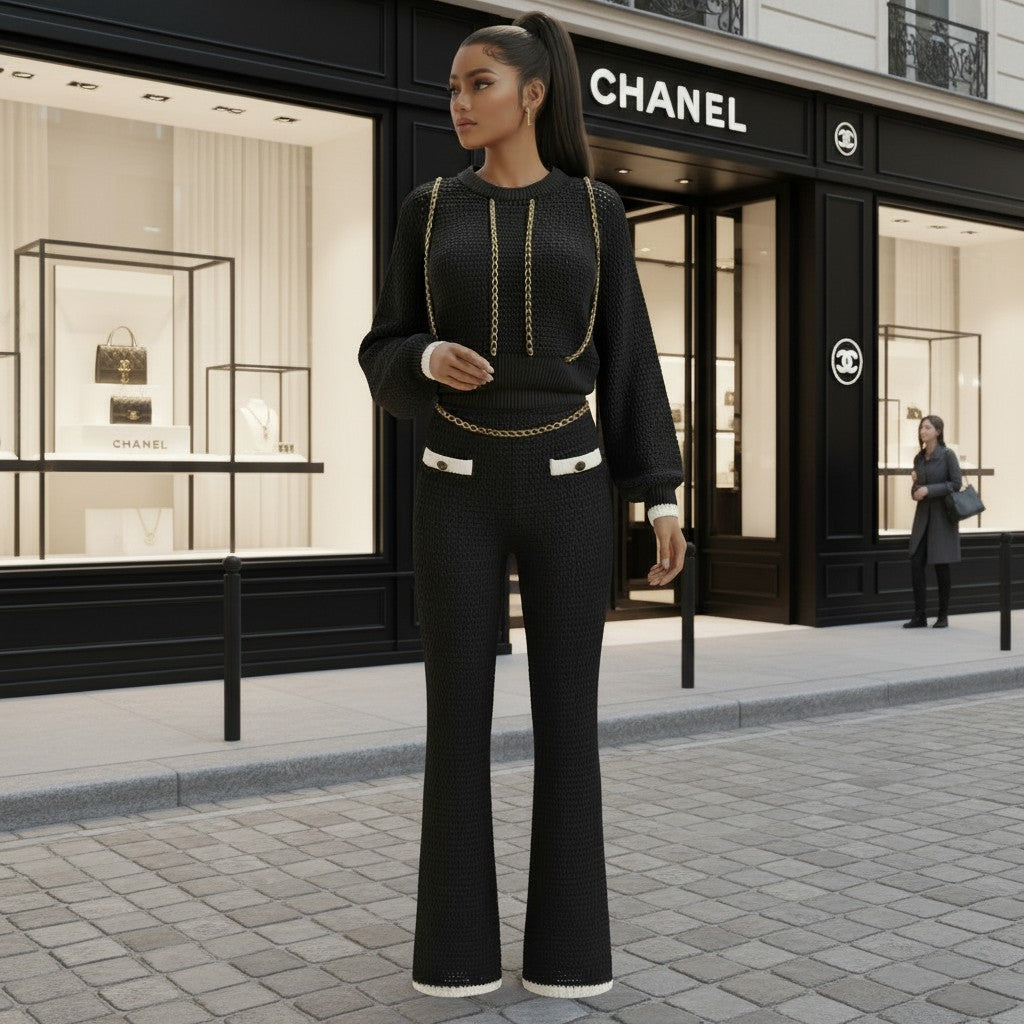Hush Boutique black crochet two-piece sweater set with gold chain detailing and white trim on pockets and cuffs.
