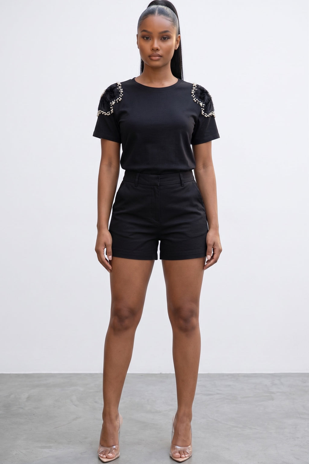 Model wearing Hush Boutique black knit Shoulder Candy Shirt with sheer floral shoulders, pearls, and crystal accents.
