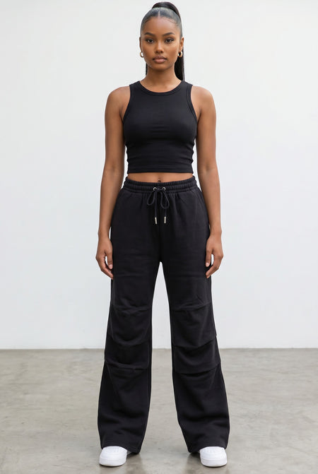 Model wearing Hush Boutique black wide leg fleece sweatpants with an elastic drawstring waist and relaxed fit.