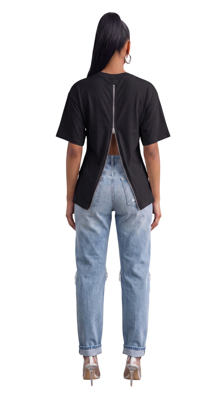 Model wearing a Hush Boutique black cotton t-shirt with a full-length functional back zipper and light wash jeans.