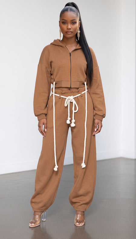 Model wearing Hush Boutique brown two-piece set with cropped zip hoodie, wide-leg sweatpants, and rope waist detail.