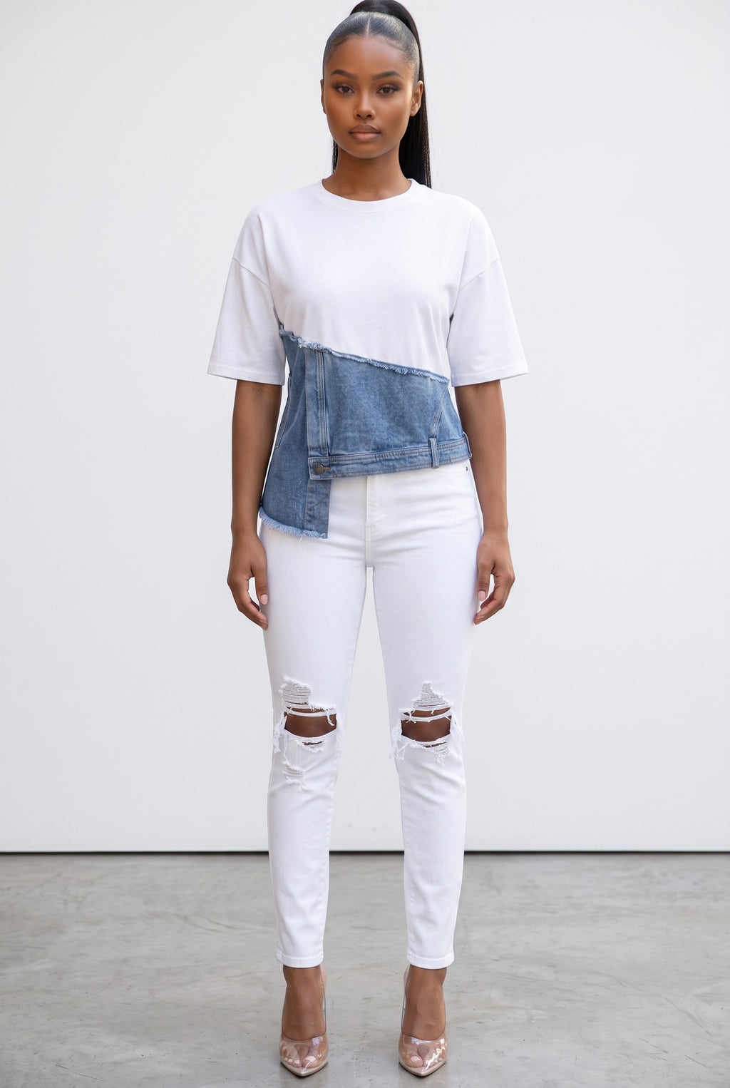 Model wearing Hush Boutique white cotton t-shirt with an asymmetrical blue denim raw-edge overlay and white jeans.