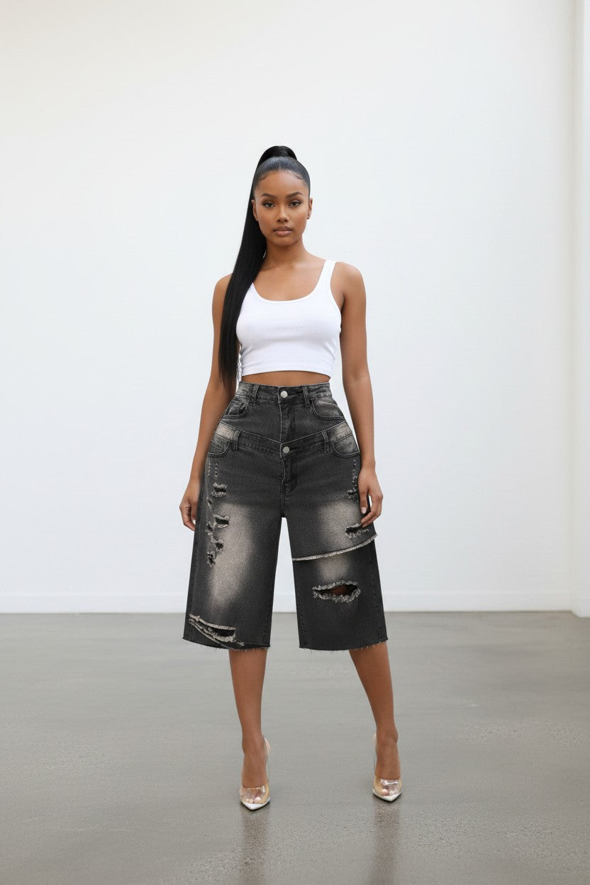 Model wearing Hush Boutique double layer distressed black denim Bermuda shorts with a white tank top