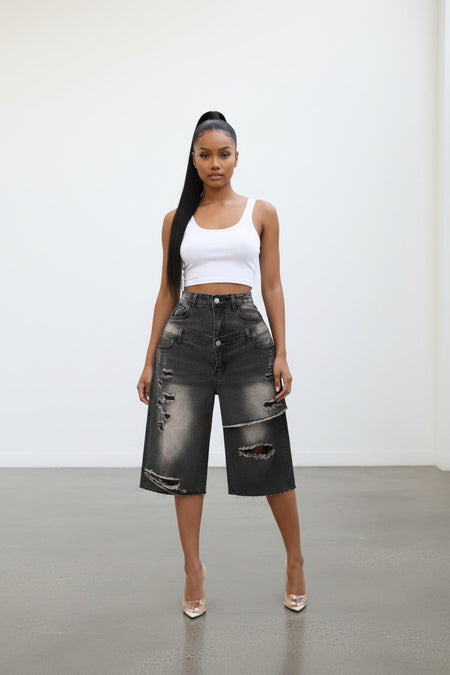 Model wearing Hush Boutique double layer distressed black denim Bermuda shorts with a white tank top