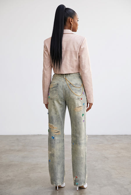 Hush Boutique wide-leg jeans with floral print, jewel embellishments, and distressing, worn with a pink jacket.