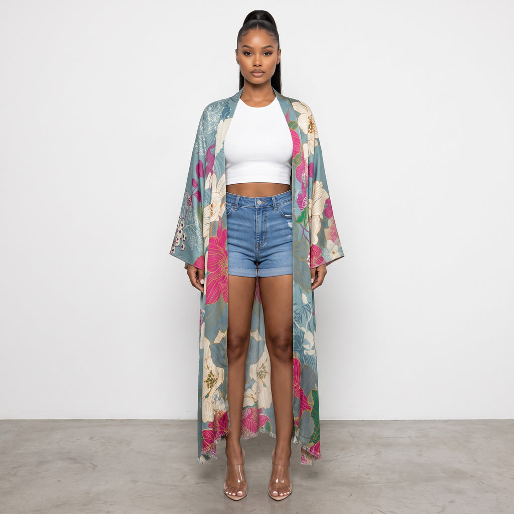 Hush Boutique maxi kimono with oversized floral print in blue, pink, and green, worn over a white tank and denim shorts