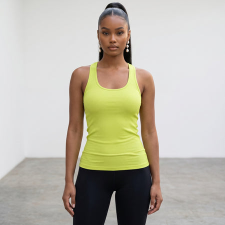 Model wearing a lime green ribbed Hush Boutique slimming spandex racerback tank top with black leggings