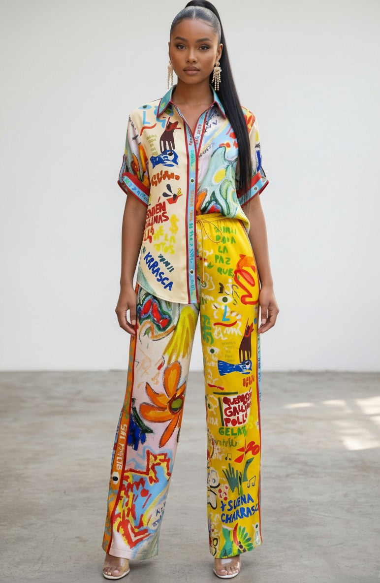 Hush Boutique Positano Postcard two piece set featuring a vibrant multi-colored graphic print shirt and matching pants.