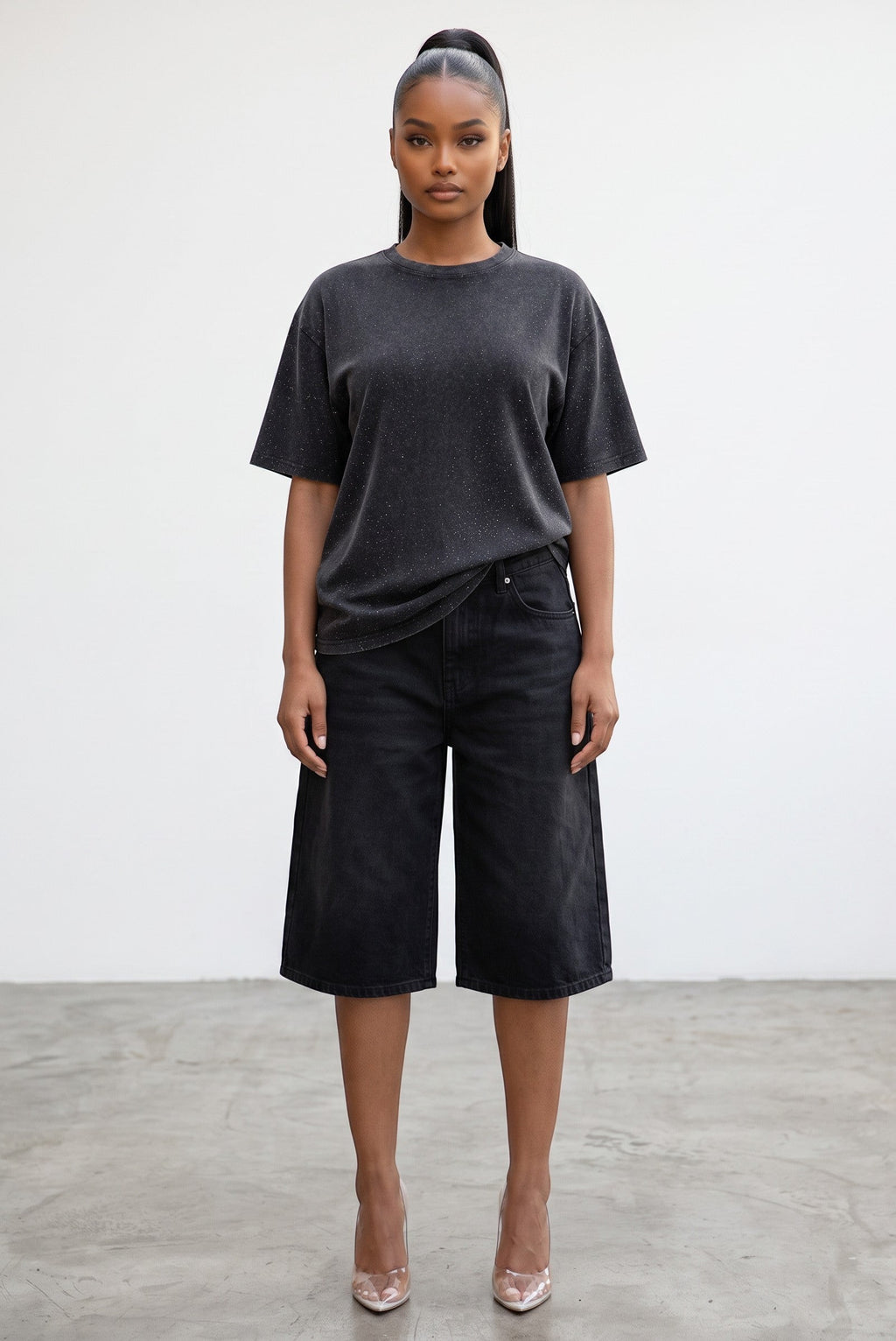 Model wearing a Hush Boutique charcoal grey oversized t-shirt with subtle rhinestone detailing and black denim shorts.