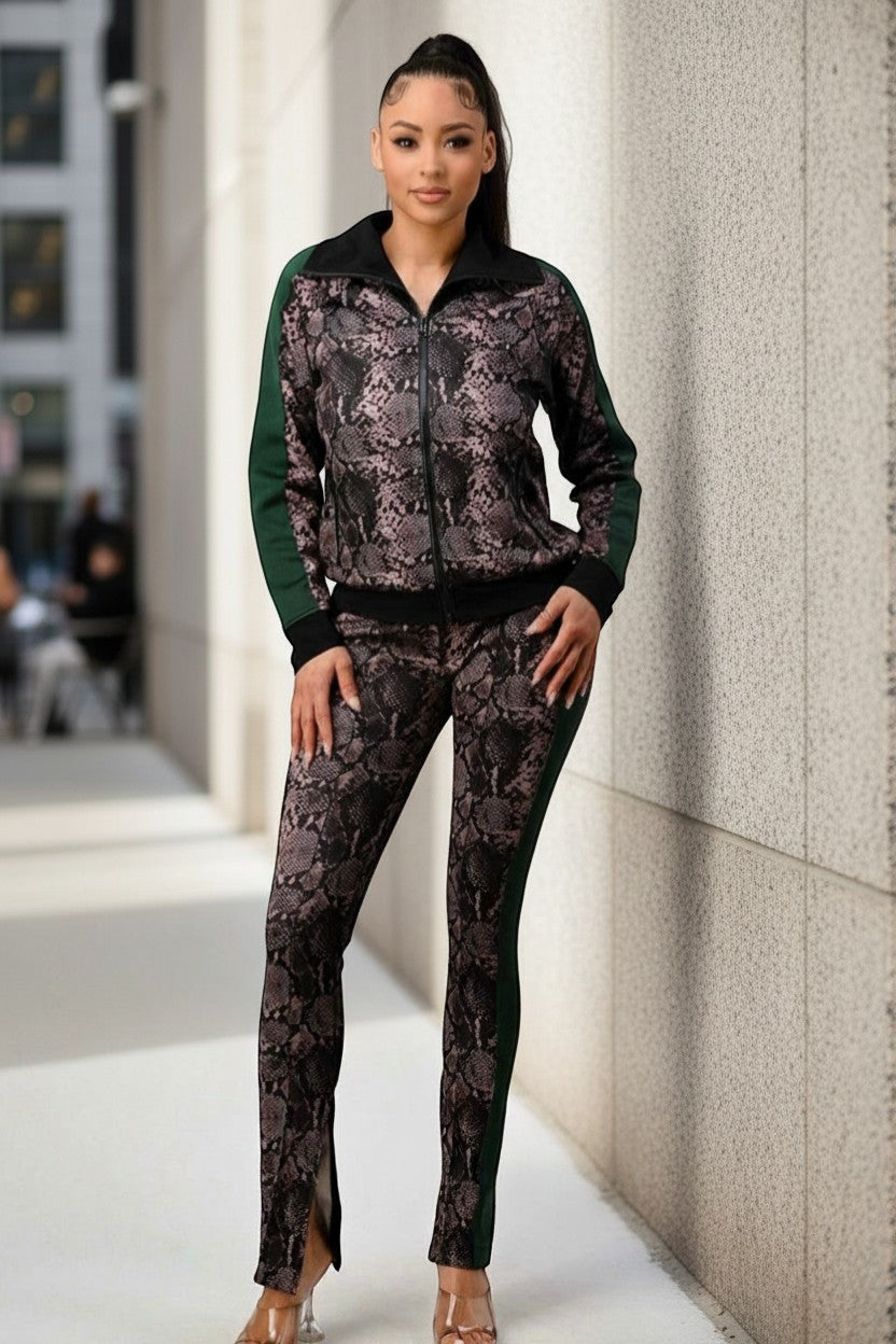Hush Boutique women's 2-piece tracksuit with snake print, black collar, and green side stripes. Features zip-up jacket and split-hem pants.