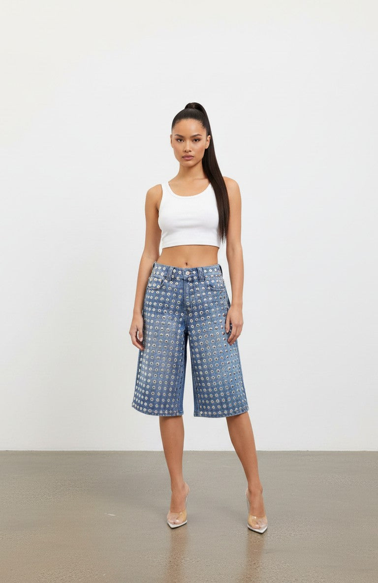 Model wearing Hush Boutique PrimRose blue denim Bermuda shorts with all-over silver stud embellishments