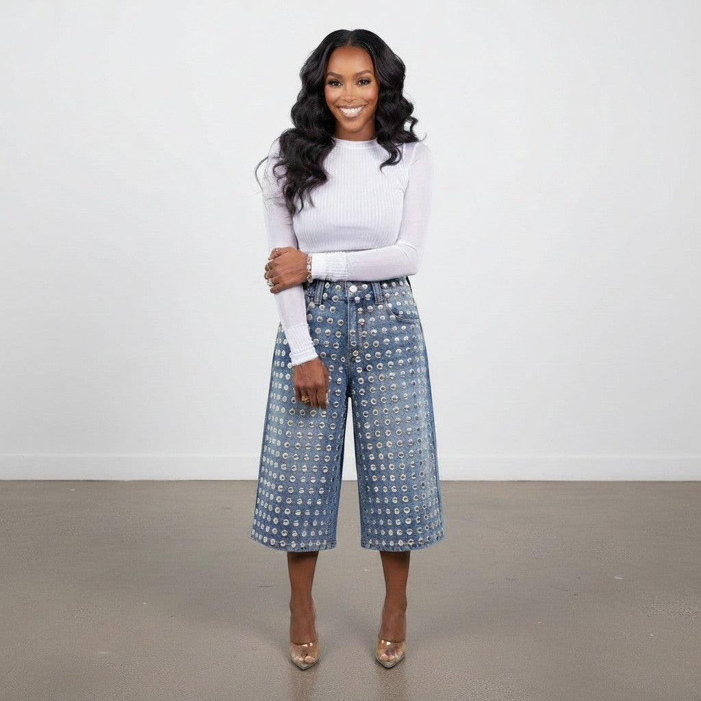 Model wearing Hush Boutique PrimRose denim Bermuda shorts with silver stud embellishments and a white long-sleeve top.