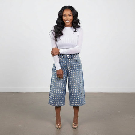 Model wearing Hush Boutique PrimRose denim Bermuda shorts with silver stud embellishments and a white long-sleeve top.