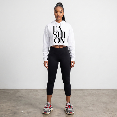 Hush Boutique white crop hoodie with FASHION graphic print worn by a model with black leggings and sneakers