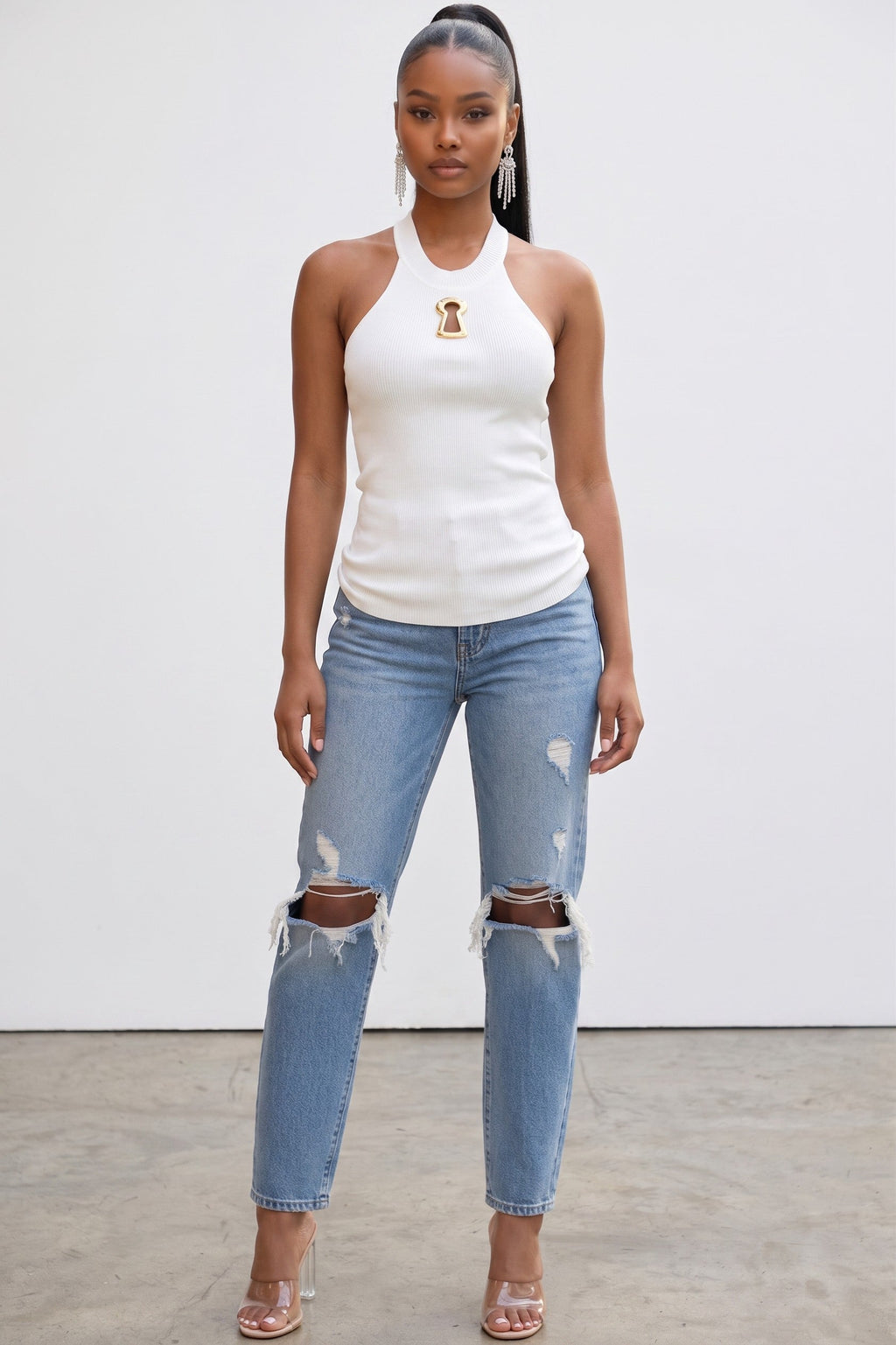 Model wearing a white Hush Boutique ribbed knit tank top featuring a high neckline and gold keyhole hardware detail.